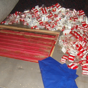 Ţigări de contrabandă ascunse în podeaua dublată a unui microbuz