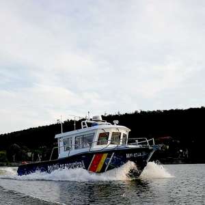 Trei persoane aflate pe un iaht pe fluviul Dunărea, sprijinite de polițiștii de frontieră